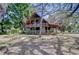 Charming two-story log home featuring a metal roof, wraparound porch and mature trees at 4126 Burrows Rd, Zephyrhills, FL 33542