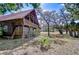Charming two-story log home featuring a metal roof, wraparound porch and mature trees at 4126 Burrows Rd, Zephyrhills, FL 33542