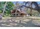 Charming two-story log home featuring a metal roof, wraparound porch and mature trees at 4126 Burrows Rd, Zephyrhills, FL 33542