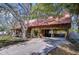 Rustic log cabin with a red metal roof, carport, and concrete driveway at 4126 Burrows Rd, Zephyrhills, FL 33542
