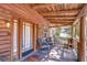 Close-up of cozy covered porch with rocking chairs, wood floors and log beam roof details at 4126 Burrows Rd, Zephyrhills, FL 33542