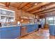 Log cabin kitchen with stainless steel appliances, wood flooring, and bright windows at 4126 Burrows Rd, Zephyrhills, FL 33542