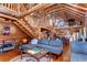 Open-concept living area featuring a vaulted ceiling, log beams, and a wooden staircase at 4126 Burrows Rd, Zephyrhills, FL 33542