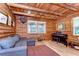 Rustic living room with wood walls, exposed beams, and large windows that provide natural light at 4126 Burrows Rd, Zephyrhills, FL 33542