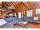 Spacious log cabin living room with wood floors, vaulted ceilings, and large couches, perfect for relaxing or entertaining at 4126 Burrows Rd, Zephyrhills, FL 33542