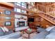 Spacious log cabin living room with a stone fireplace and unique wooden staircase at 4126 Burrows Rd, Zephyrhills, FL 33542