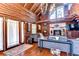 Stunning living room with log walls, a stone fireplace, and vaulted ceiling at 4126 Burrows Rd, Zephyrhills, FL 33542