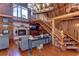 Impressive living area featuring exposed log beams, a fireplace, and a grand staircase at 4126 Burrows Rd, Zephyrhills, FL 33542