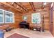 Warm living room featuring log walls, wood floors, natural lighting, and comfortable furniture at 4126 Burrows Rd, Zephyrhills, FL 33542