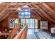Bright open loft with wood walls and a ceiling fan, featuring floor to ceiling windows at 4126 Burrows Rd, Zephyrhills, FL 33542