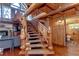 Intricate wood staircase featuring custom wood posts and view of the living and bathroom at 4126 Burrows Rd, Zephyrhills, FL 33542