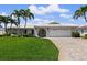 Charming single-story home with a well-manicured lawn, palm trees, and a brick driveway leading to a two-car garage at 4333 48Th S Ave, St Petersburg, FL 33711