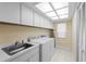Well-lit laundry room with ample storage cabinets and washer/dryer units at 4333 48Th S Ave, St Petersburg, FL 33711