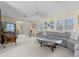 Spacious living room with a comfortable sectional sofa, large windows, and a glimpse of the outdoor patio area at 4333 48Th S Ave, St Petersburg, FL 33711