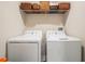 Convenient laundry room equipped with a washer, dryer, and overhead shelving for storage at 4550 Globe Thistle Dr, Tampa, FL 33619