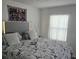 Serene bedroom featuring a queen-sized bed with a decorative tapestry and large window at 5131 Forum Blvd, Holiday, FL 34690
