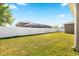 Wide view of the lush green backyard, complete with a white fence and screened-in pool area at 5453 Suncatcher Dr, Wesley Chapel, FL 33545