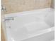 Clean white bathtub with chrome fixtures and light beige tile surround at 5453 Suncatcher Dr, Wesley Chapel, FL 33545