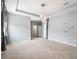 Carpeted bedroom with tray ceiling, decorative lighting, and neutral paint at 5453 Suncatcher Dr, Wesley Chapel, FL 33545