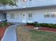 Condo building entrance with well-kept landscaping featuring flowers, mulch, and stepping stones leading to the unit at 5660 80Th N St # A102, St Petersburg, FL 33709