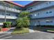 Three story condo building featuring a well maintained lawn with mature palm trees and tropical landscaping at 5660 80Th N St # A102, St Petersburg, FL 33709