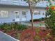 Condo building exterior showcasing front entrance featuring tropical landscaping, flowers, and decorative mulch at 5660 80Th N St # A102, St Petersburg, FL 33709