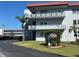 Three story condo building with carports, signage, and well-manicured green spaces in a tropical locale at 5660 80Th N St # A102, St Petersburg, FL 33709