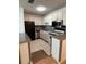 Bright kitchen with stainless steel appliances, white cabinets, tile flooring, and neutral countertops at 5660 80Th N St # A102, St Petersburg, FL 33709
