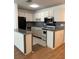 Bright kitchen with stainless steel appliances, white cabinets, tile flooring, and neutral countertops at 5660 80Th N St # A102, St Petersburg, FL 33709