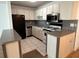 Bright kitchen with stainless steel appliances, white cabinets, tile flooring, and neutral countertops at 5660 80Th N St # A102, St Petersburg, FL 33709