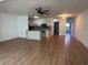 Open concept living space with modern wood-look flooring, ceiling fan, and white trim at 5660 80Th N St # A102, St Petersburg, FL 33709