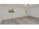 Bright bedroom with light gray wood-look floors, white walls, recessed lighting, and two windows at 6136 56Th N Ave, St Petersburg, FL 33709