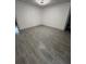 Bedroom showcasing modern gray wood-look flooring, crisp white walls, and ample natural light at 6136 56Th N Ave, St Petersburg, FL 33709