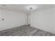Bright bedroom with light gray wood-look floors and white walls and door to hallway at 6136 56Th N Ave, St Petersburg, FL 33709