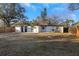 Exterior view of the home and backyard featuring a fence and large trees at 6136 56Th N Ave, St Petersburg, FL 33709