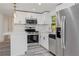 Modern kitchen with stainless steel appliances, white cabinets, and quartz countertops at 6136 56Th N Ave, Kenneth City, FL 33709