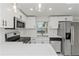 Stylish white kitchen with stainless steel appliances, quartz countertops, and ample cabinet space at 6136 56Th N Ave, Kenneth City, FL 33709