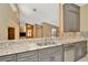 Open kitchen with stainless steel sink, speckled granite countertops, and view into the living area at 713 Dorado Ct, Brandon, FL 33511