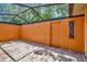 Private screened patio featuring brick pavers and an orange accent wall with a door at 713 Dorado Ct, Brandon, FL 33511