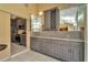 Wet bar located in sunroom with pool view, tile backsplash and gray cabinetry at 713 Dorado Ct, Brandon, FL 33511