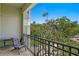 Relaxing outdoor balcony setting with a comfortable chair overlooking lush trees and clear blue sky at 728 Seagate Dr, Tampa, FL 33602