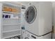 Bright laundry room features new washer and dryer next to built-in storage and shelving at 728 Seagate Dr, Tampa, FL 33602