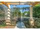 Gated tennis court with a pergola entrance featuring a trellis at 728 Seagate Dr, Tampa, FL 33602
