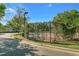 Tennis court surrounded by trees on a sunny day with a paved walkway nearby at 728 Seagate Dr, Tampa, FL 33602
