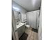 Well-lit bathroom with vanity, storage cabinet, and shower with patterned curtain at 772 71St N Ave, St Petersburg, FL 33702