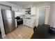 Well-lit kitchen with stainless steel appliances and modern white cabinets, open to the dining area at 772 71St N Ave, St Petersburg, FL 33702