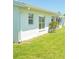 Exterior view of the home showcasing well-maintained lawn, white siding, and windows providing ample natural light at 9117 41St N Way # 5, Pinellas Park, FL 33782
