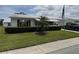 Charming single-story home featuring a well-maintained lawn and a quaint palm tree accentuating the manicured landscaping at 9117 41St N Way # 5, Pinellas Park, FL 33782