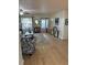 Spacious living area featuring wood floors, a comfortable armchair, and ample natural light from the adjacent covered patio at 9117 41St N Way # 5, Pinellas Park, FL 33782