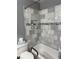 Clean shower area with a white tub, handrails, and marble tile surround with decorative accents at 9117 41St N Way # 5, Pinellas Park, FL 33782